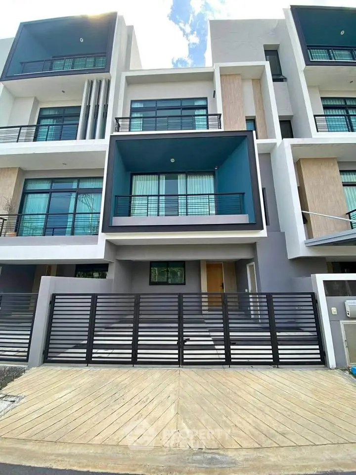 Modern multi-story townhouse with sleek design and spacious balconies in urban setting.