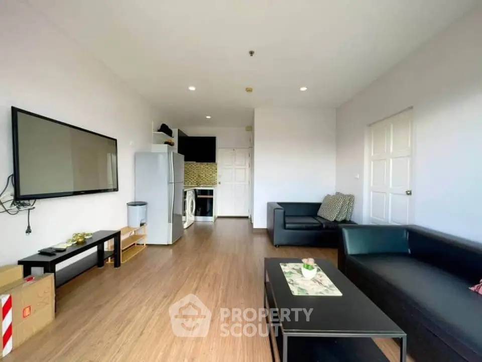 Modern living room with sleek furniture and open kitchen layout, perfect for urban living.