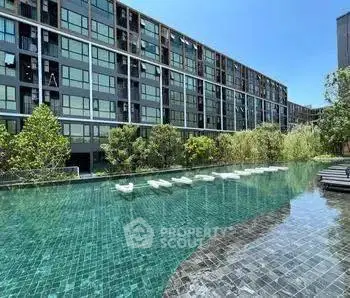 Luxurious modern apartment complex with stunning pool and lush greenery.