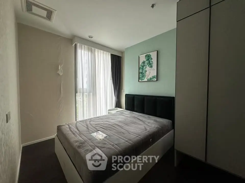 Modern bedroom with stylish decor and natural light, featuring a comfortable bed and sleek wardrobe.