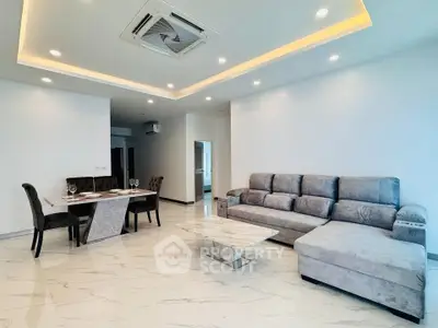 Spacious modern living room with elegant marble flooring and plush gray sofa.