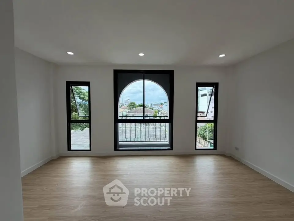 Spacious living room with large windows offering a stunning view, perfect for natural light lovers.