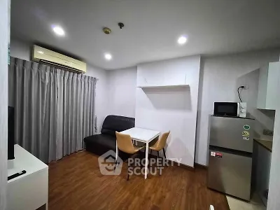 Modern living room with sleek furniture and appliances in a cozy apartment setting.