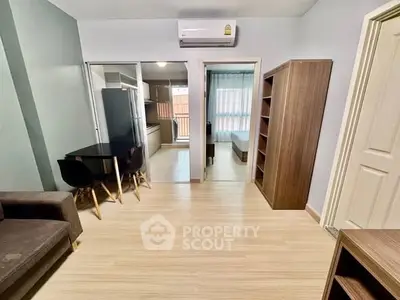 Modern apartment interior with open layout, featuring a cozy living area, dining space, and a glimpse of the bedroom.