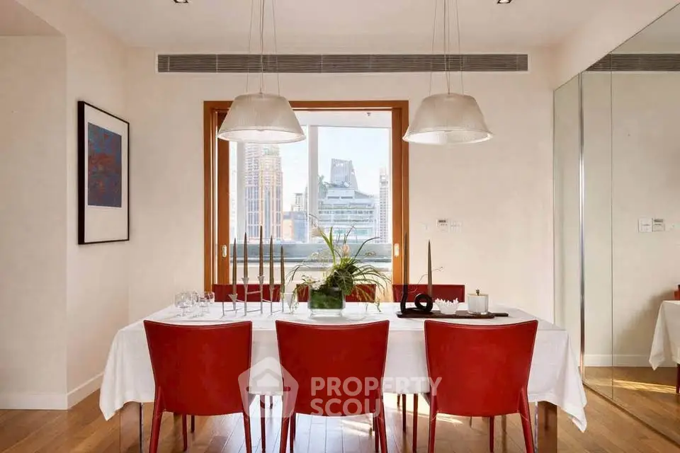 Elegant dining room with red chairs and city view, perfect for entertaining guests.