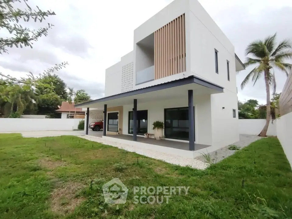 Modern two-story house with spacious lawn and contemporary design.