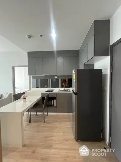 Modern kitchen with sleek cabinetry and dining area in contemporary apartment