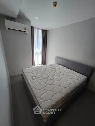 Modern bedroom with minimalist design featuring a comfortable bed and air conditioning.