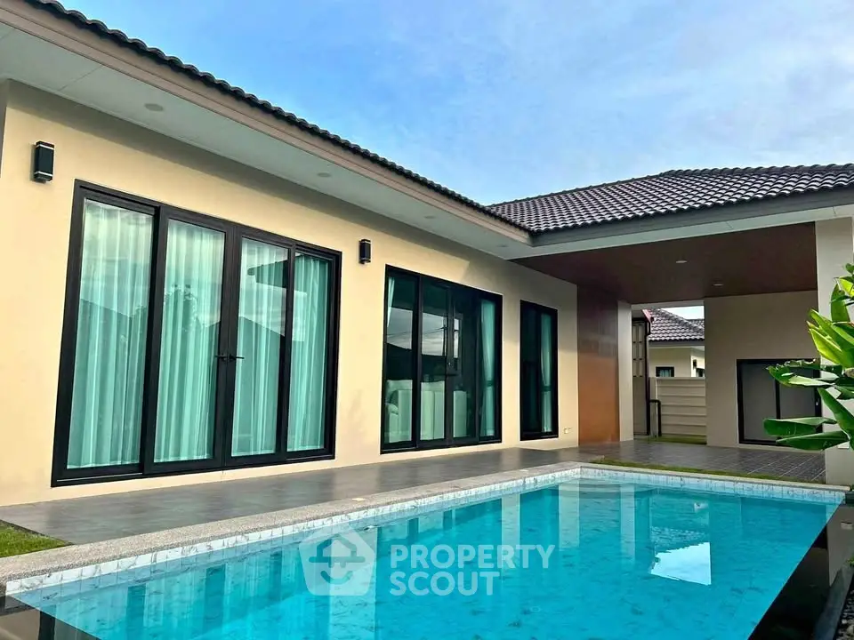 Modern single-story house with private pool and large glass doors, perfect for luxury living.