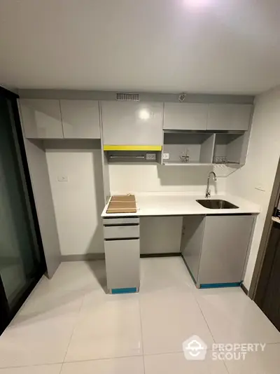 Modern compact kitchen with sleek cabinetry and integrated sink