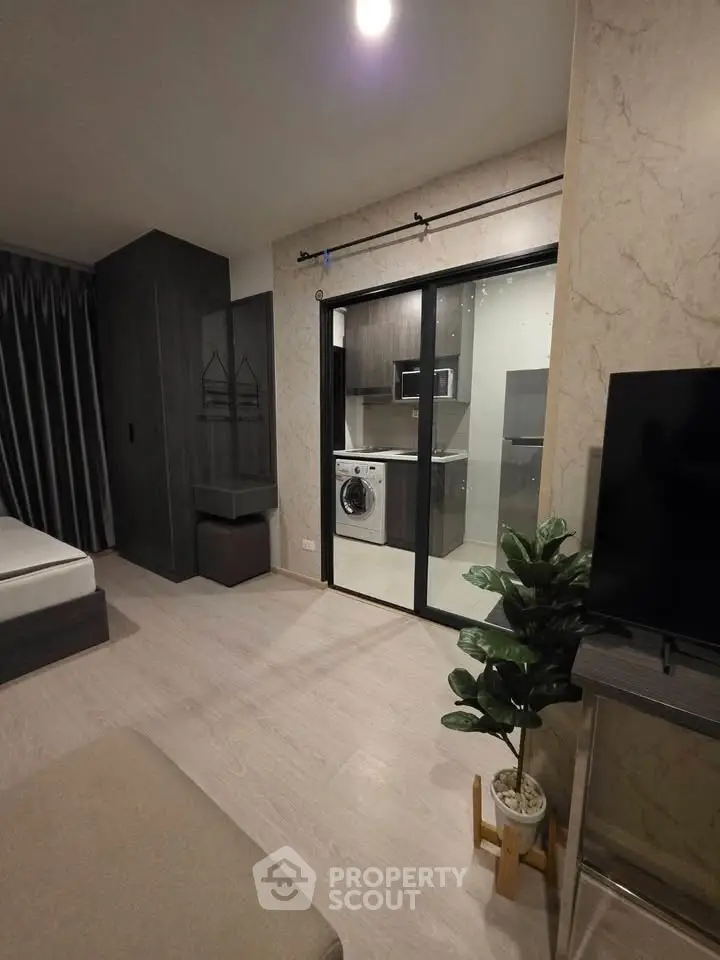 Modern apartment interior with sleek kitchen and washing machine, featuring elegant decor and spacious layout.