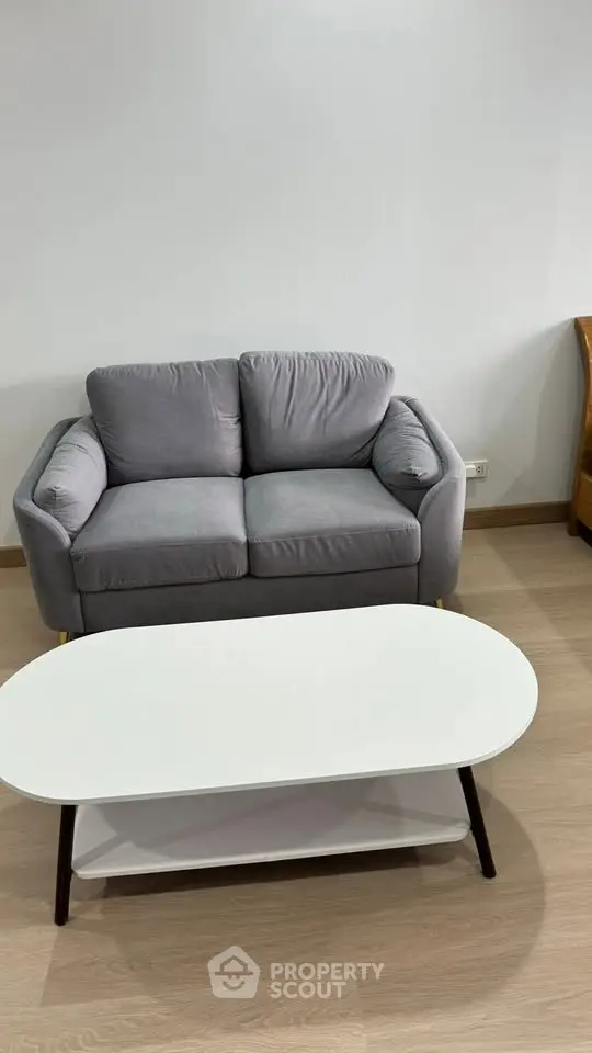 Cozy living room with modern gray sofa and sleek white coffee table.