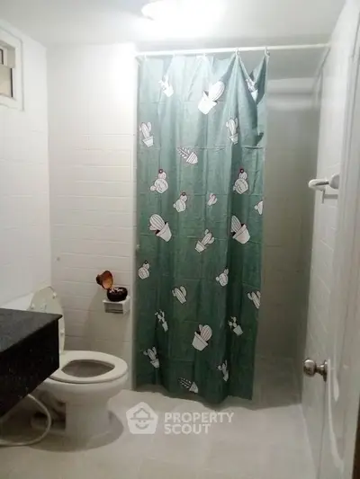 Cozy bathroom with cactus-themed shower curtain and modern fixtures.