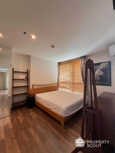 Cozy bedroom with wooden flooring and natural light in modern apartment