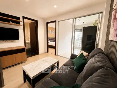Modern living room with cozy sofa, marble coffee table, and TV, leading to bedroom and balcony.