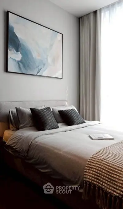 Elegant bedroom with modern decor and large window, featuring cozy bedding and stylish artwork.