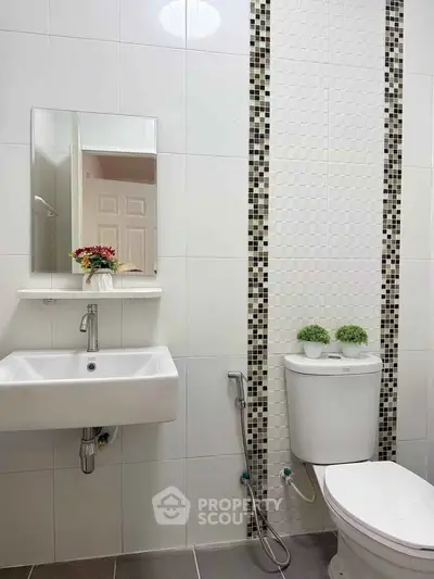 Modern bathroom with sleek white tiles and stylish mosaic accents
