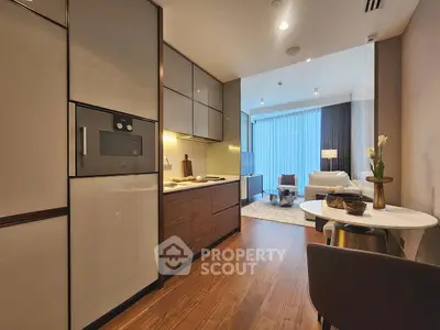 Modern open-layout kitchen and living area with sleek design and cozy ambiance.