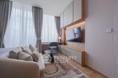 Modern living room with large windows, cozy sofa, and wall-mounted TV in a stylish apartment.