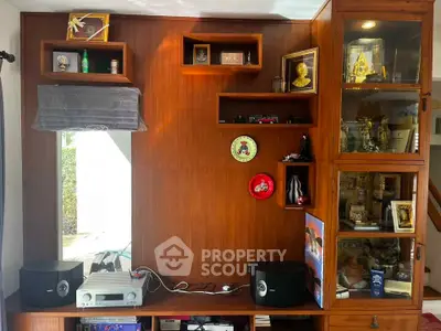 Elegant wooden living room entertainment center with decorative shelves and audio system.