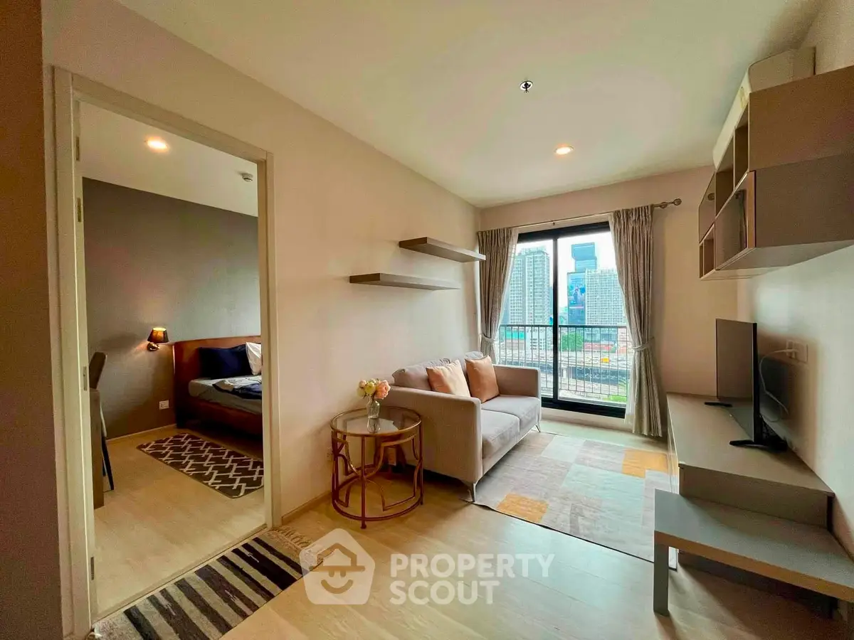 Modern living room with city view, cozy seating, and stylish decor in a high-rise apartment.