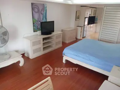 Spacious bedroom with modern furnishings and hardwood floors