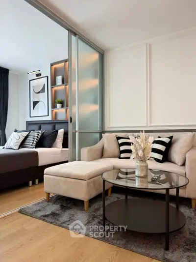 Modern living room with stylish decor and cozy seating area adjacent to a bedroom.