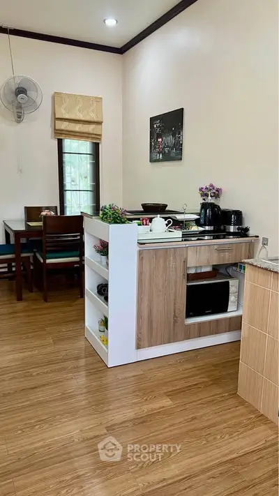 Charming kitchen with open layout and dining area, featuring modern appliances and wooden flooring.