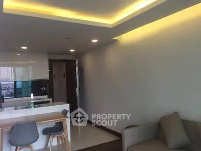 Modern living room with sleek kitchen and cozy seating area