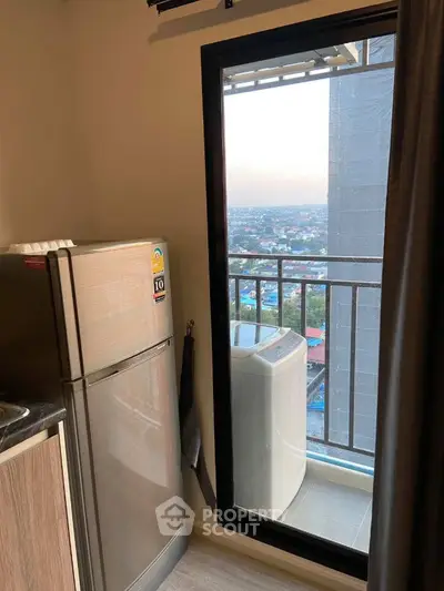 Modern apartment kitchen with balcony view and washing machine
