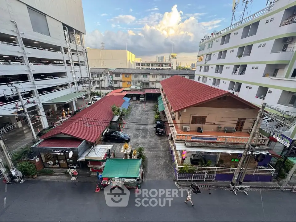 Aerial view of urban residential area with parking and multi-story buildings.