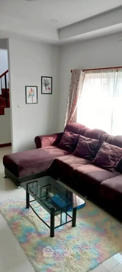 Cozy living room with plush sofa and colorful rug, perfect for relaxation.