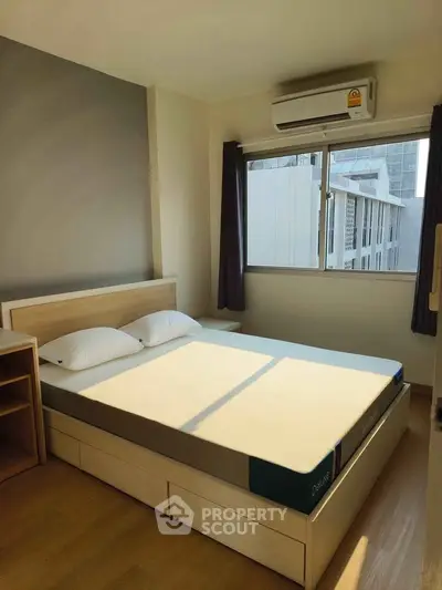 Bright and cozy bedroom with modern furnishings and large window view.