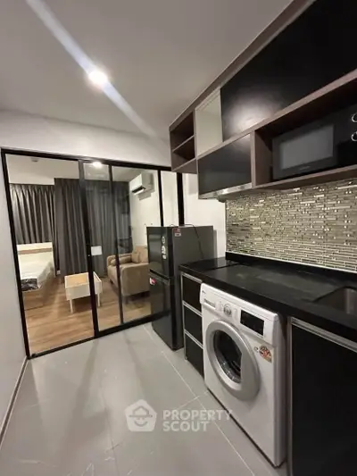 Modern kitchen with sleek appliances and stylish backsplash in a contemporary apartment.