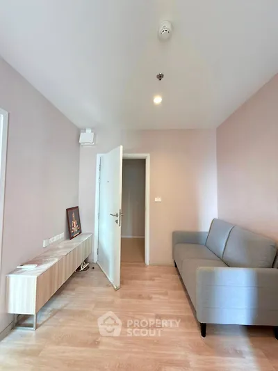 Cozy living room with modern sofa and wooden flooring in a stylish apartment.