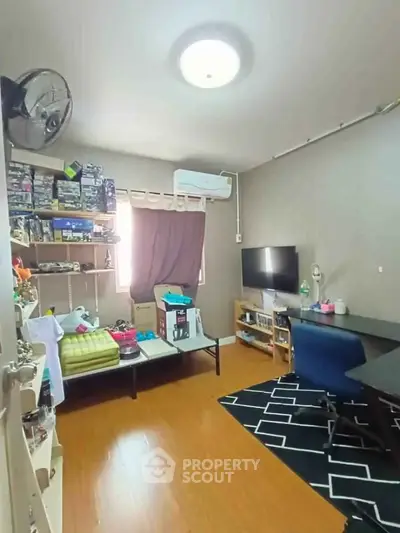 Cozy study room with modern desk, TV, and ample storage space.