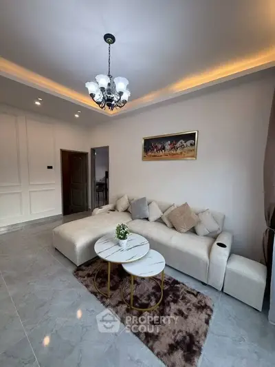 Elegant living room with modern chandelier and cozy sectional sofa