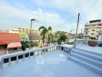 Spacious balcony with city view and palm trees, perfect for relaxation.