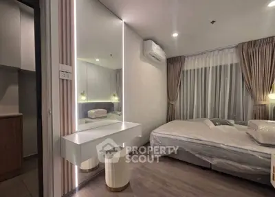 Modern bedroom with stylish decor and large mirror, featuring cozy lighting and air conditioning.