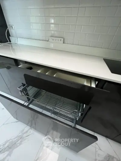 Modern kitchen with sleek cabinetry and pull-out wire basket storage