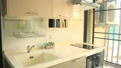 Modern kitchen with sleek design, featuring induction cooktop and built-in microwave.