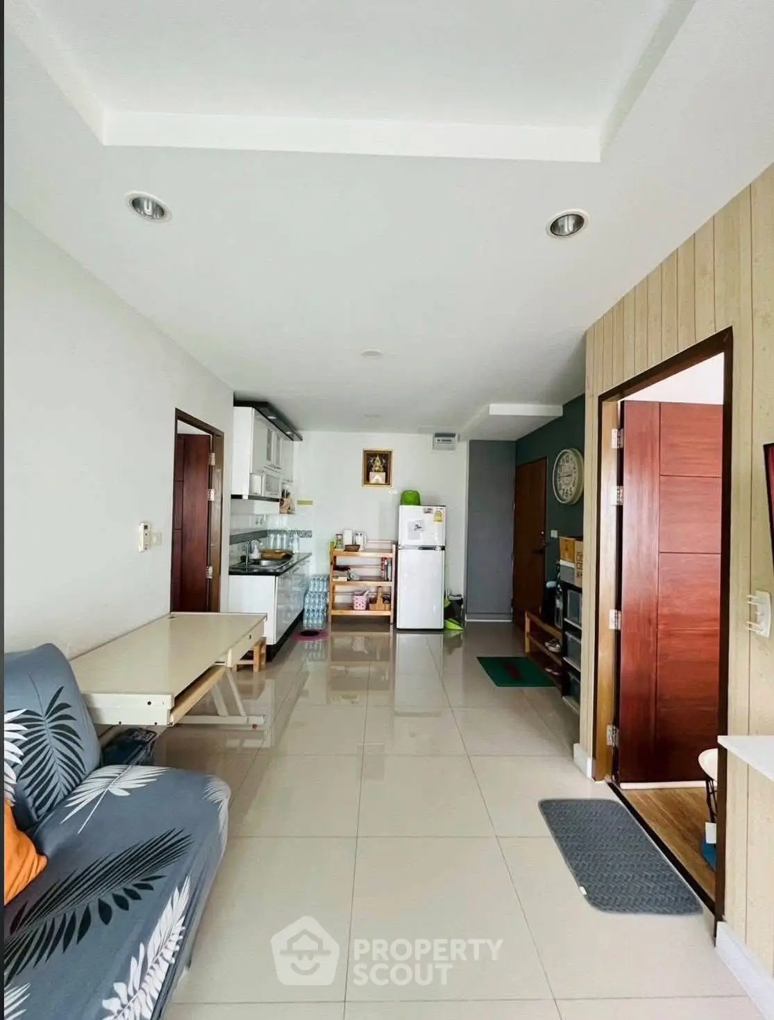 Modern open-layout living room with kitchen, featuring sleek design and natural light.