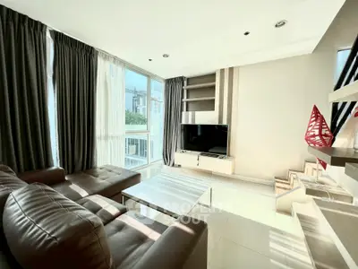 Modern living room with large windows, stylish furniture, and natural light in a contemporary apartment.