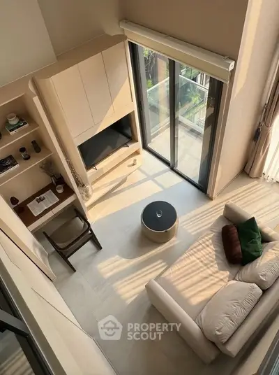Modern living room with large windows and balcony view, featuring cozy sofa and stylish decor.