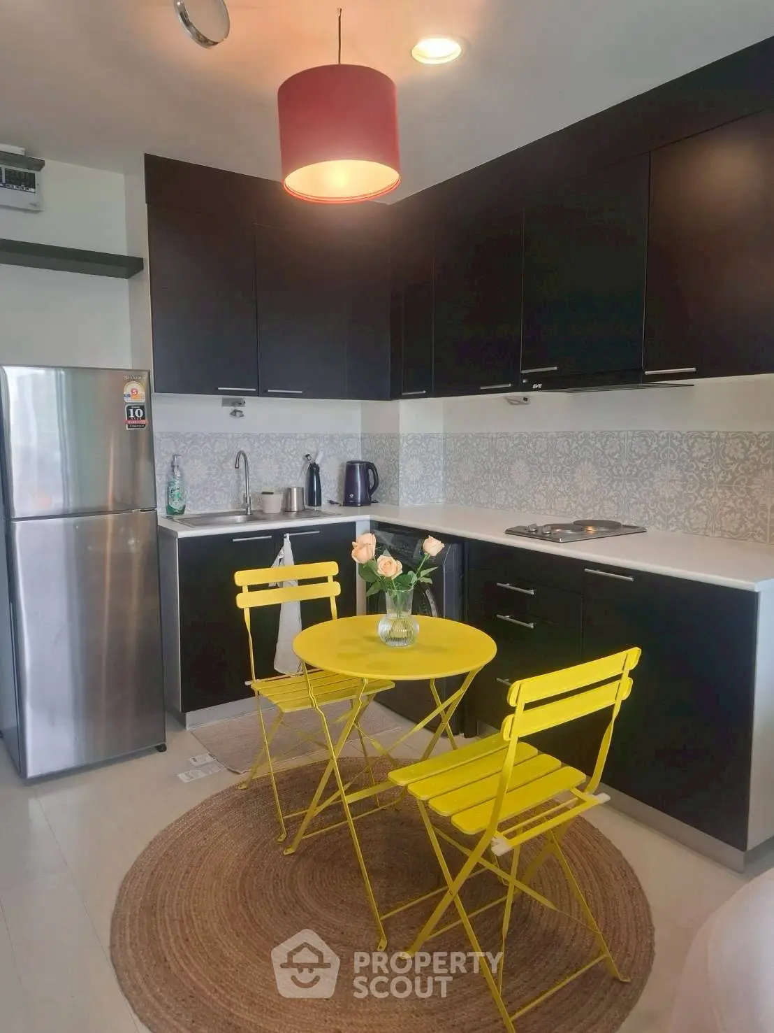 Chic modern kitchen with vibrant yellow dining set and sleek black cabinetry.