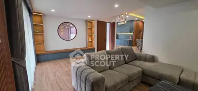 Spacious modern living room with plush gray sofa and elegant wooden accents