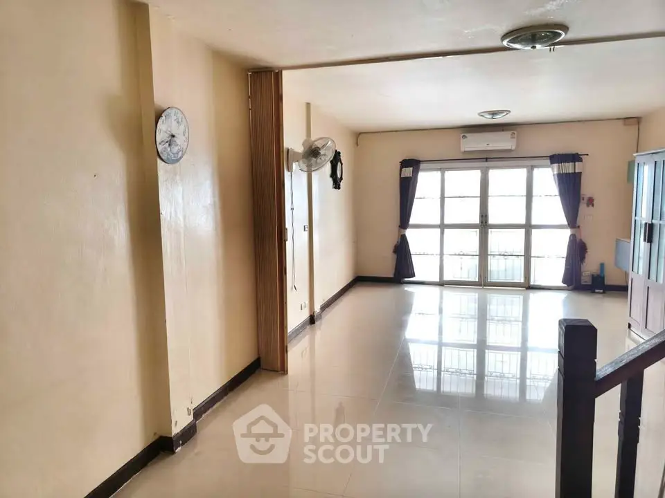 Spacious living room with large windows and modern decor in a bright apartment.