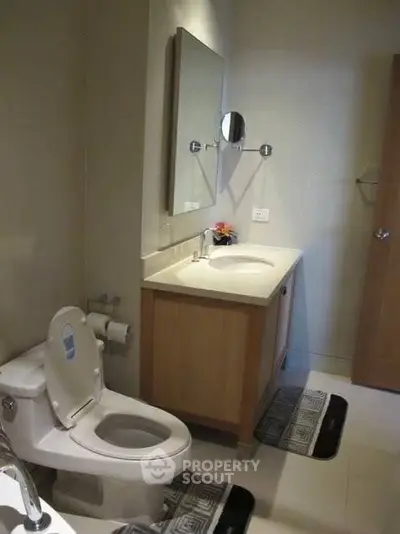 Modern bathroom with sleek vanity and toilet, featuring elegant fixtures and neutral tones.