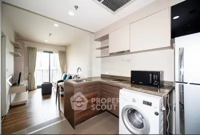 Modern open-layout kitchen with washing machine and sleek appliances in stylish apartment.