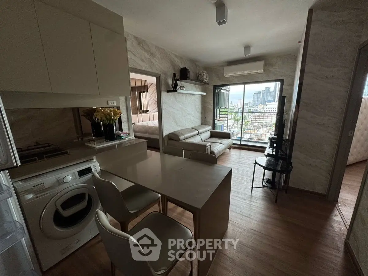 Modern open-layout living room with kitchen and city view balcony